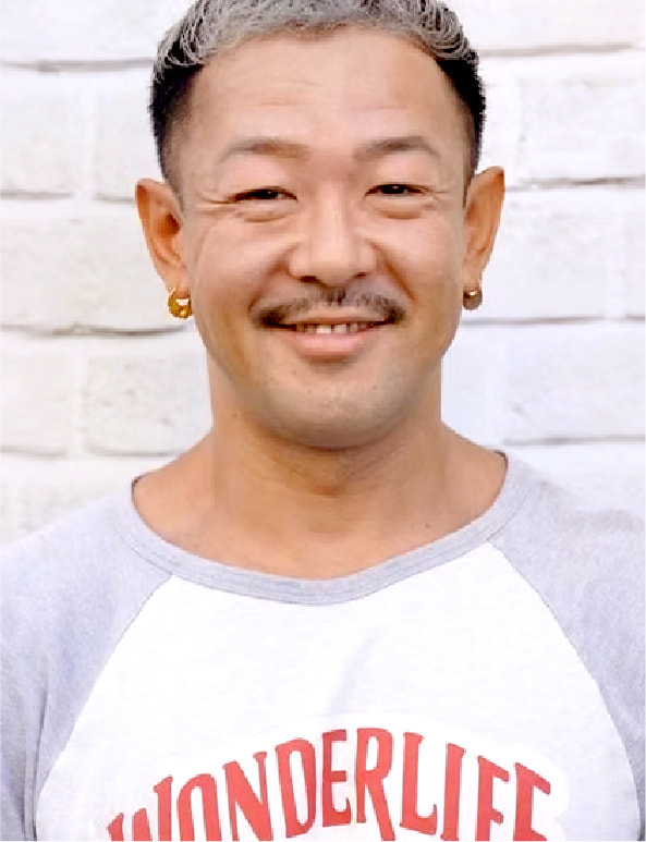 白い背景の前で笑顔を見せる男性トレーナーのポートレート写真